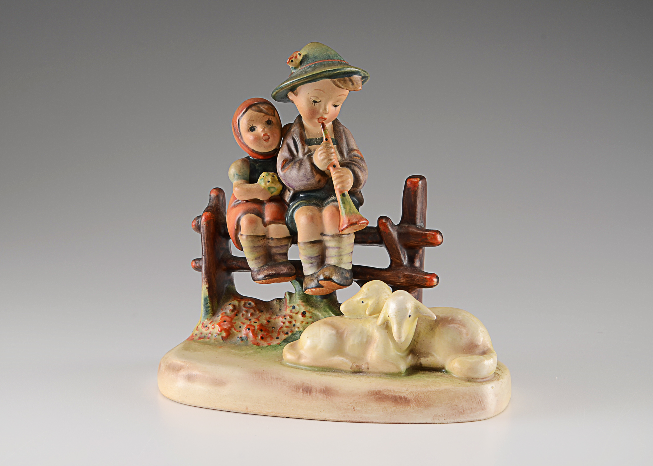 hummel boy sitting on fence
