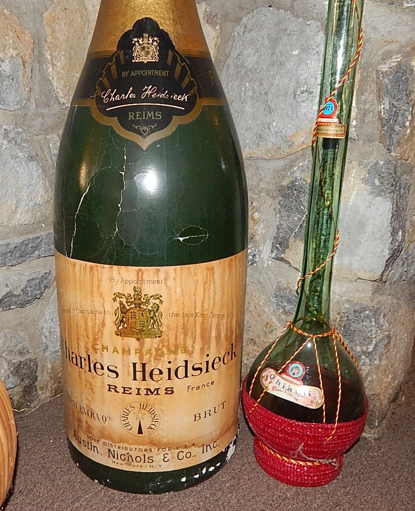 Two Glass Wine Bottles and Large Plastic Champagne Bottle