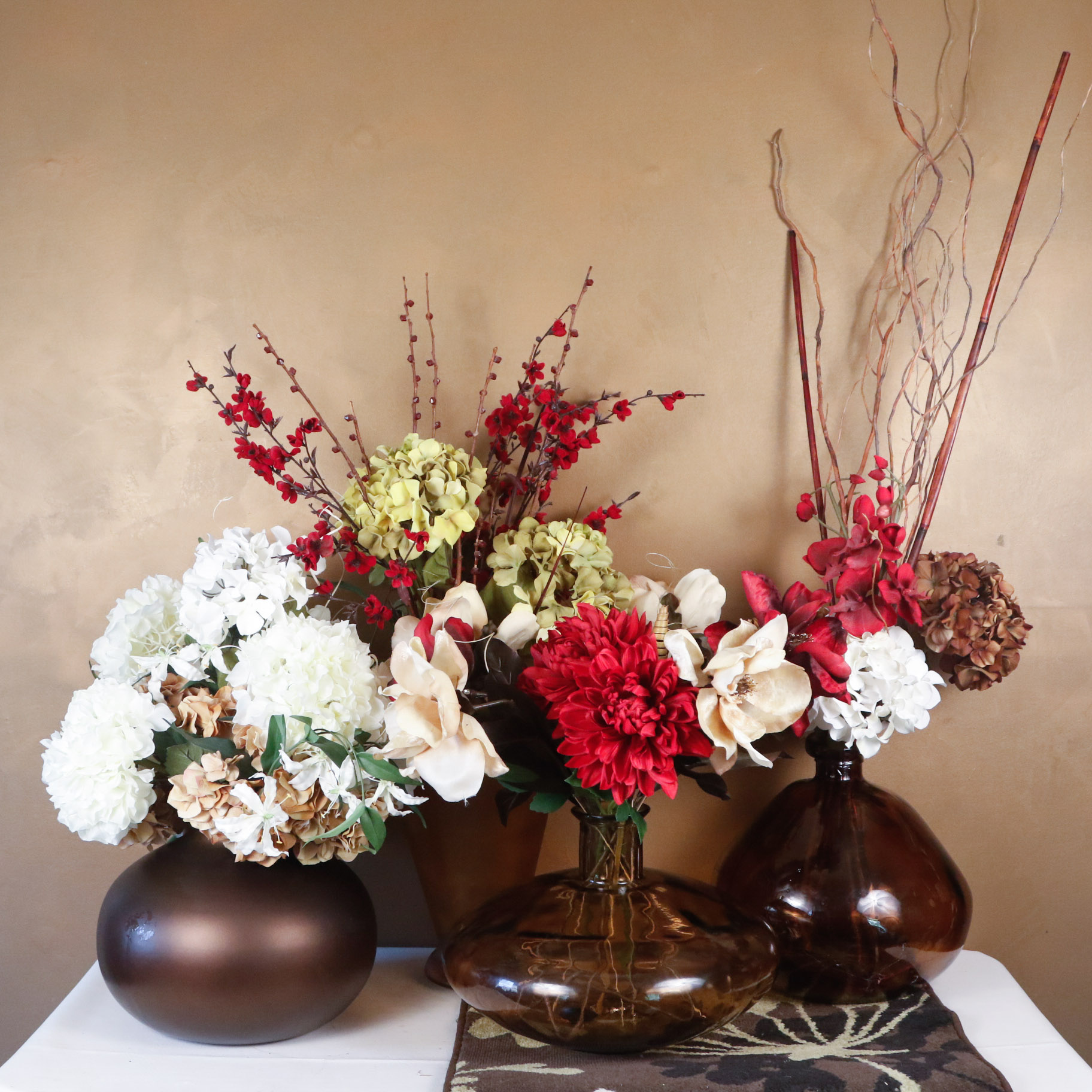 Faux Floral Arrangements In Brown Glass Vases With Small Area Rug
